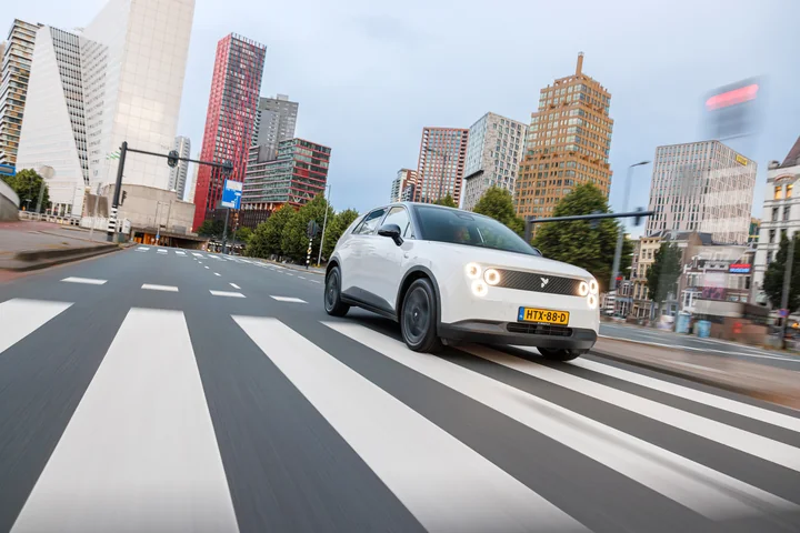 A white Firefly in motion against the Rotterdam skyline.
