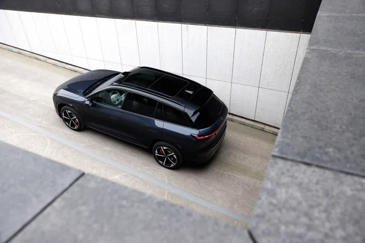 NIO EL7 photographed from above beside modern architecture.